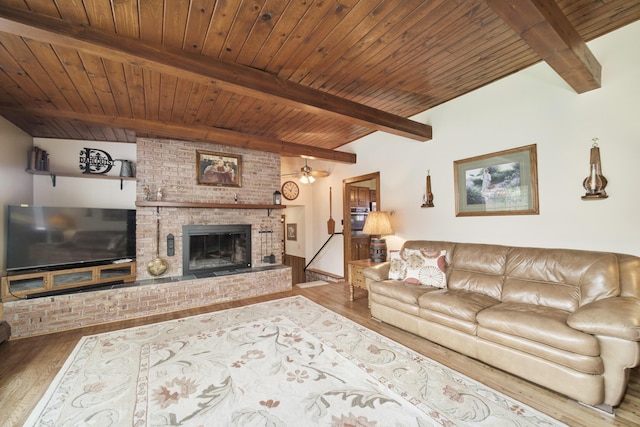 living area featuring wood ceiling, wood finished floors, a fireplace, and beamed ceiling
