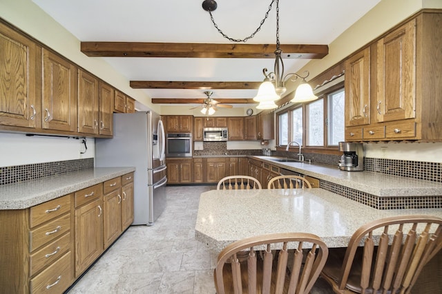 kitchen featuring a sink, stainless steel appliances, brown cabinets, beamed ceiling, and hanging light fixtures