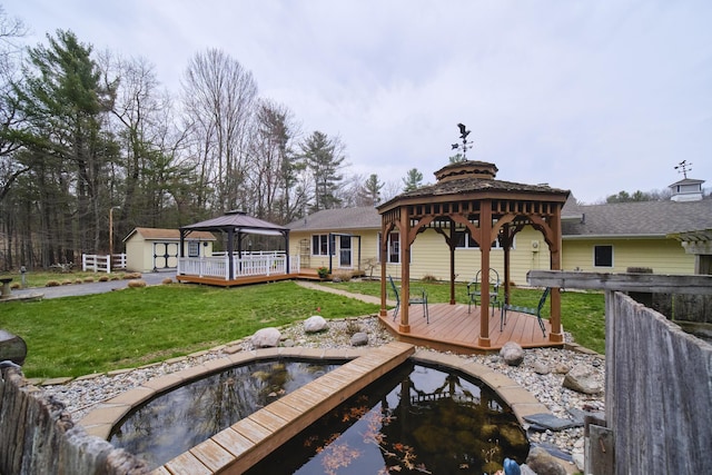 exterior space featuring a lawn, an outbuilding, a gazebo, a wooden deck, and a storage unit
