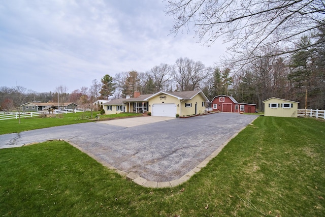 single story home featuring aphalt driveway, fence, a garage, and a front lawn
