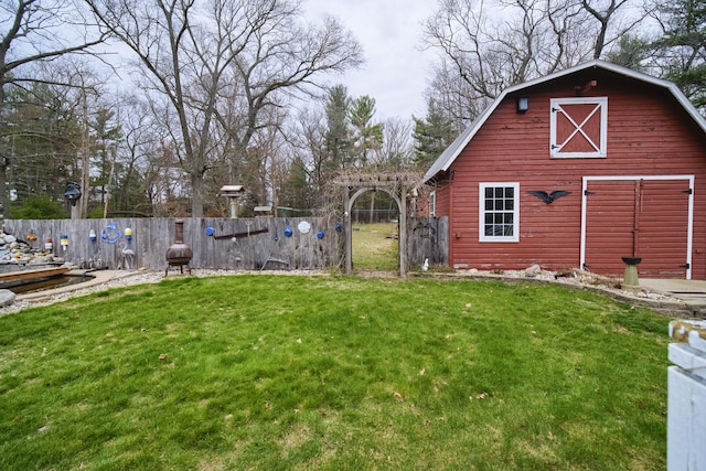 view of yard featuring fence, an outbuilding, and a barn