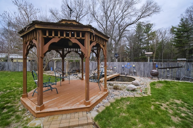 wooden terrace featuring a fenced backyard, a gazebo, and a lawn