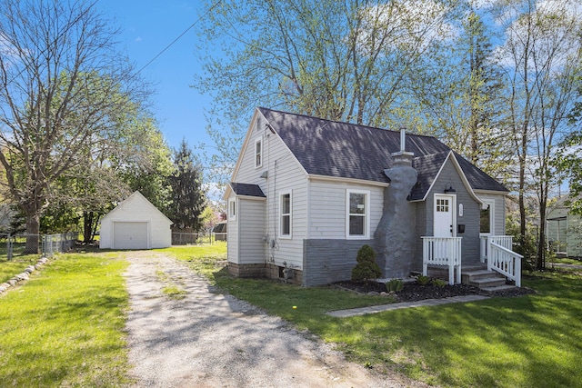 view of front of house featuring a front yard, an outdoor structure, a garage, and fence