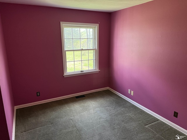 8367 S Douglas Rd, Bedford, MI 48144 - empty room featuring visible vents, baseboards, and dark colored carpet