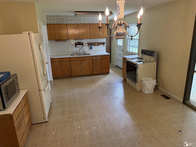 8367 S Douglas Rd, Bedford, MI 48144 - kitchen with a sink, brown cabinetry, white appliances, a chandelier, and light countertops