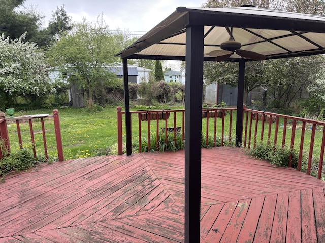 wooden terrace featuring a yard, a gazebo, and ceiling fan