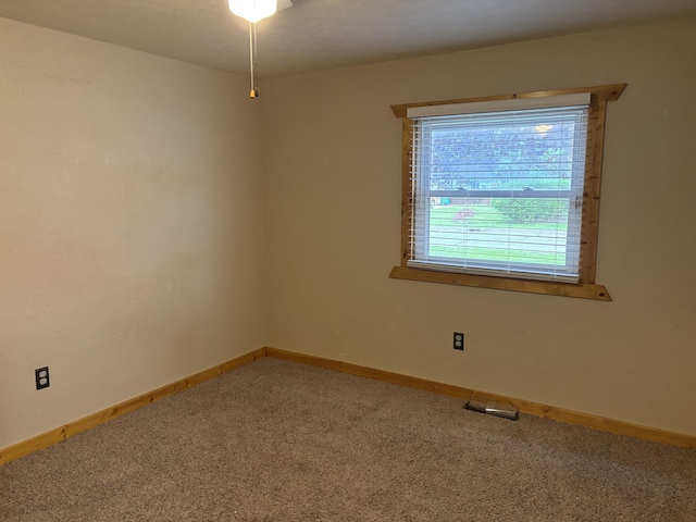 carpeted spare room with visible vents and baseboards
