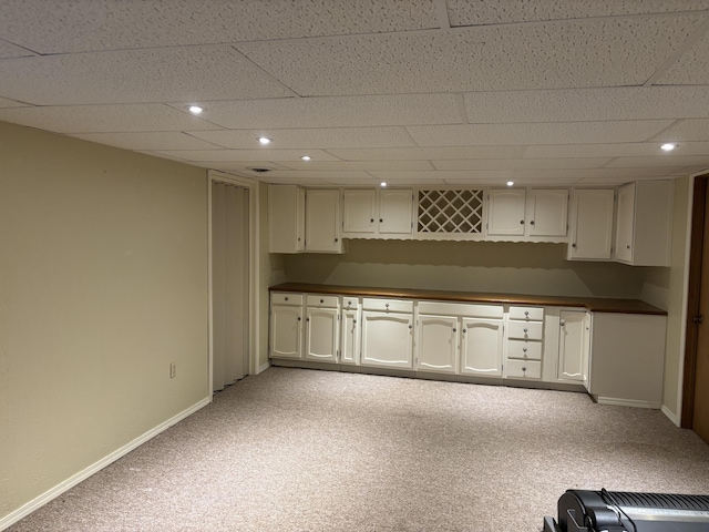 kitchen featuring light carpet, baseboards, dark countertops, and recessed lighting