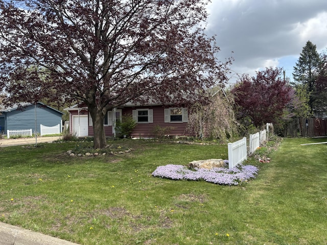 view of front of house featuring a front yard, fence, and a garage