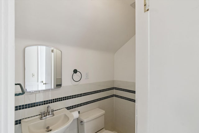 6572 Larme Ave, Allen Park, MI 48101 - half bathroom featuring tile walls, toilet, vaulted ceiling, and a sink