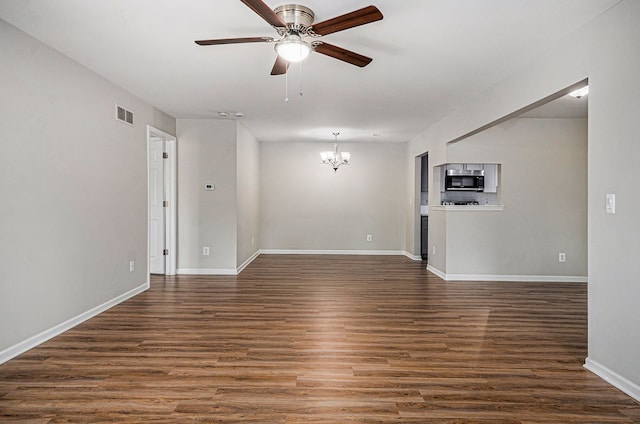 unfurnished room featuring a chandelier, dark wood finished floors, a ceiling fan, and baseboards
