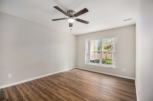 spare room featuring dark wood-style flooring, baseboards, and ceiling fan