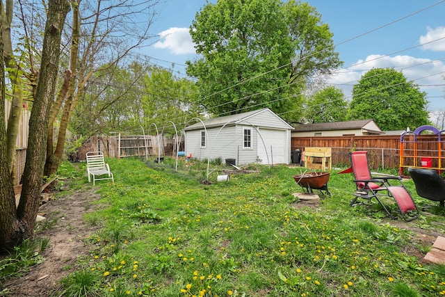 933 Cameron Ave, Pontiac, MI 48340 - view of yard featuring a fire pit, an outbuilding, and a garage