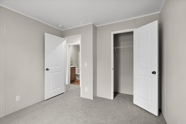 unfurnished bedroom with crown molding, a closet, and carpet floors