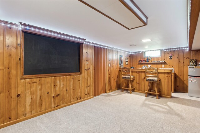 indoor wet bar featuring light colored carpet and wooden walls