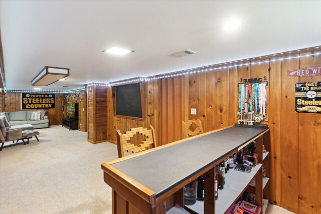 carpeted dining space with wooden walls