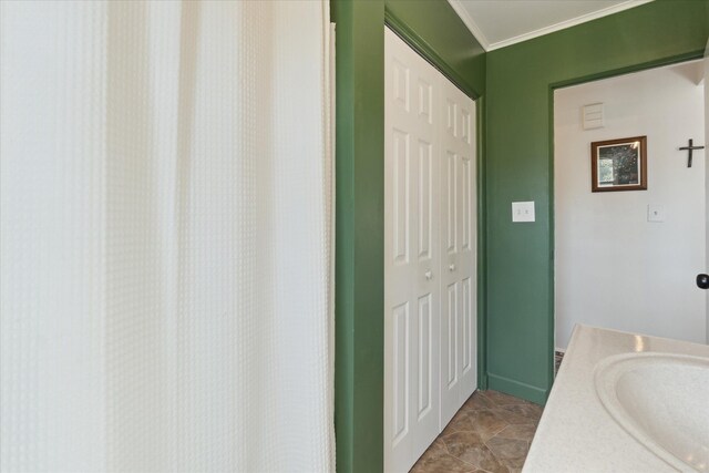 bathroom featuring a sink and crown molding