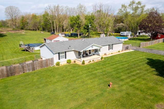 back of house featuring a yard, a patio, roof with shingles, and a fenced backyard