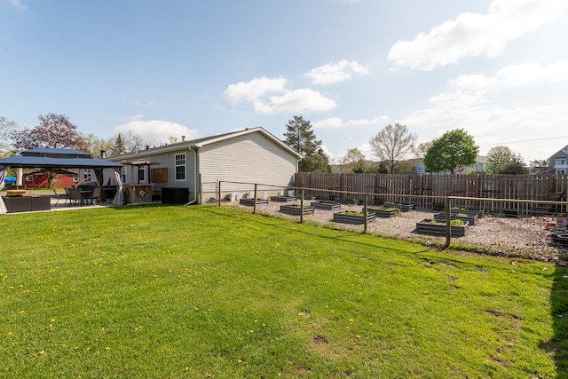 view of yard with cooling unit, a vegetable garden, fence, and a gazebo