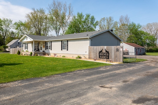 view of front of property with covered porch, fence, and a front lawn