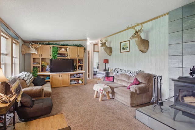 living room featuring light carpet, a wood stove, crown molding, and a textured ceiling