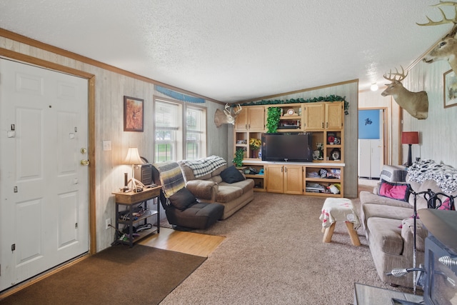 carpeted living room featuring crown molding, a textured ceiling, wood walls, and lofted ceiling
