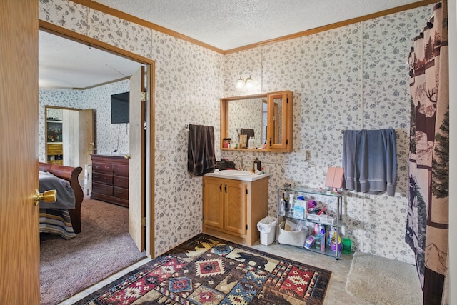 bathroom featuring a textured ceiling, vanity, crown molding, and wallpapered walls