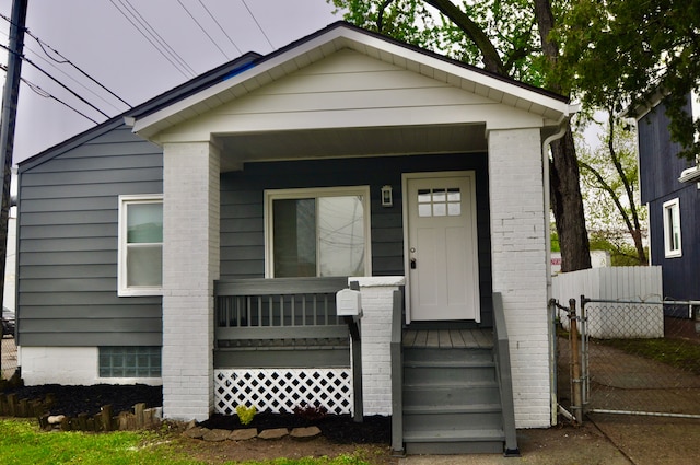 view of front of house featuring fence and a porch