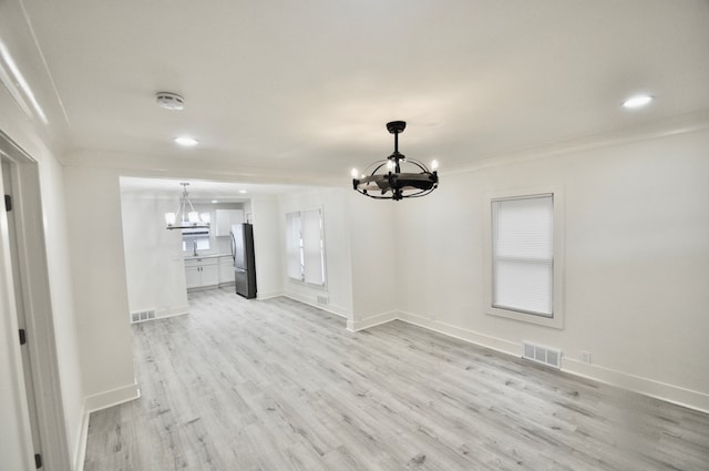 unfurnished dining area with a chandelier, light wood finished floors, recessed lighting, baseboards, and ornamental molding