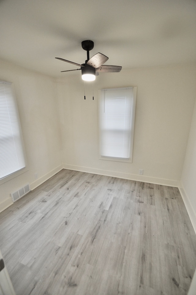 empty room featuring a ceiling fan, wood finished floors, and baseboards