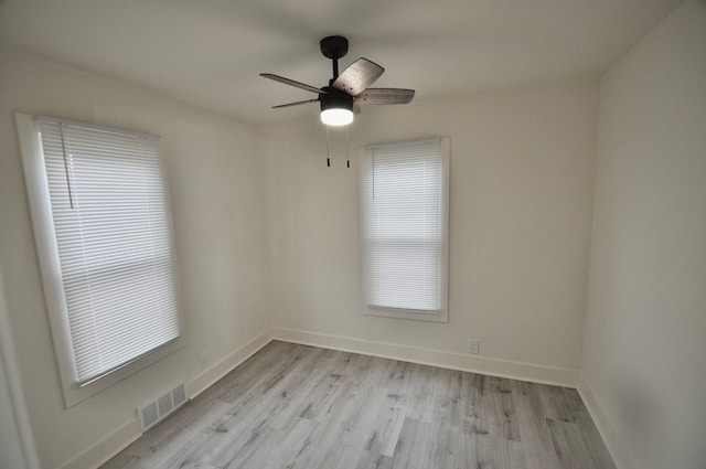 spare room with light wood-style floors, baseboards, and a ceiling fan