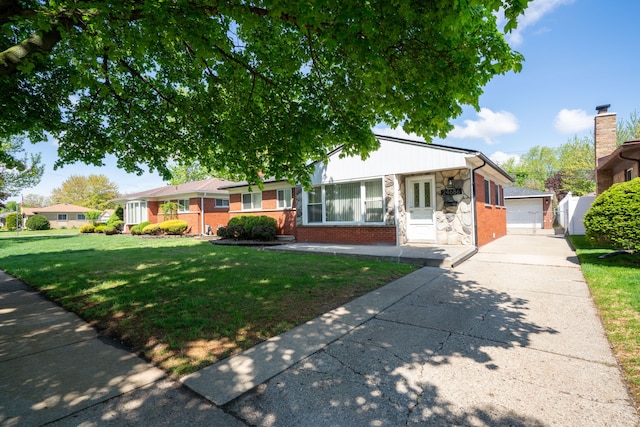 view of front of home featuring brick siding, a front yard, stone siding, and an outbuilding
