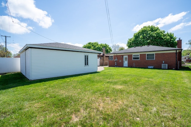back of property featuring central AC, a chimney, and brick siding