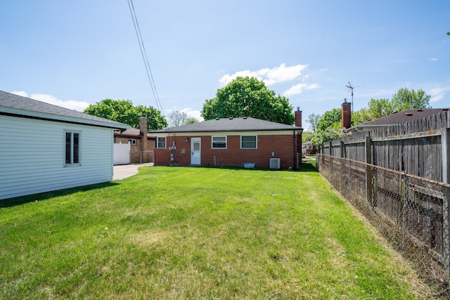back of property featuring brick siding, a chimney, and cooling unit