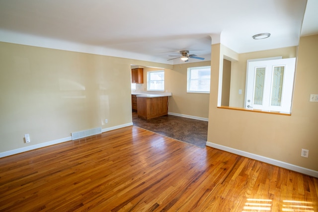 unfurnished room featuring wood finished floors, ceiling fan, and baseboards