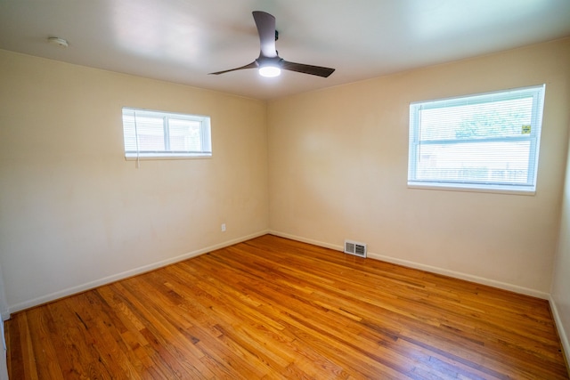 unfurnished room featuring light wood-style floors, ceiling fan, baseboards, and a smoke detector
