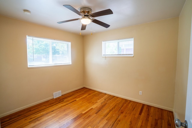 empty room with light wood-style flooring, baseboards, a smoke detector, and a ceiling fan