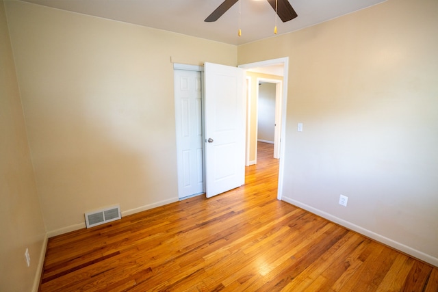 spare room with ceiling fan, light wood finished floors, and baseboards