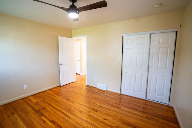 unfurnished bedroom featuring baseboards, light wood-type flooring, a closet, and ceiling fan