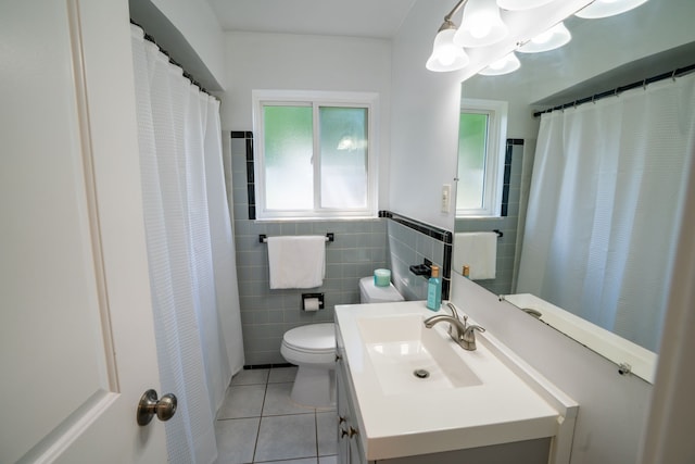 bathroom with tile patterned flooring, toilet, tile walls, vanity, and a chandelier