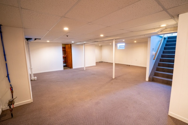 finished below grade area featuring carpet floors, stairs, recessed lighting, baseboards, and a paneled ceiling
