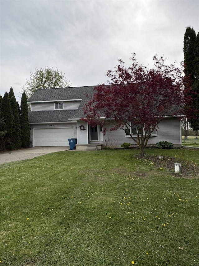 view of front facade with a garage, a front yard, a shingled roof, and driveway
