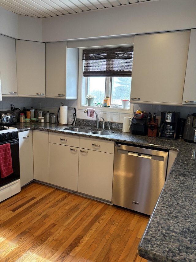 kitchen featuring light wood finished floors, a sink, gas range oven, dishwasher, and decorative backsplash