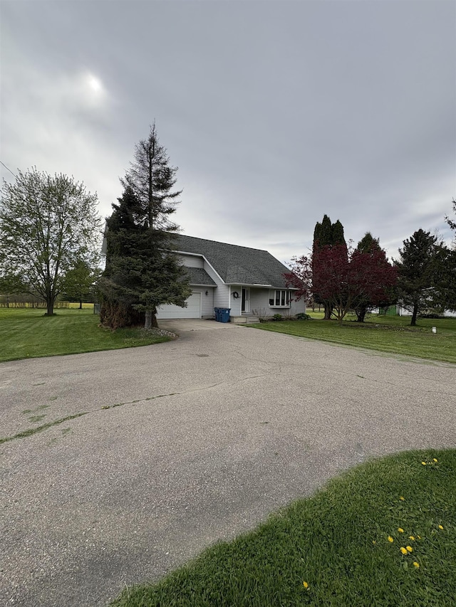 view of front of property featuring a front yard, an attached garage, and driveway