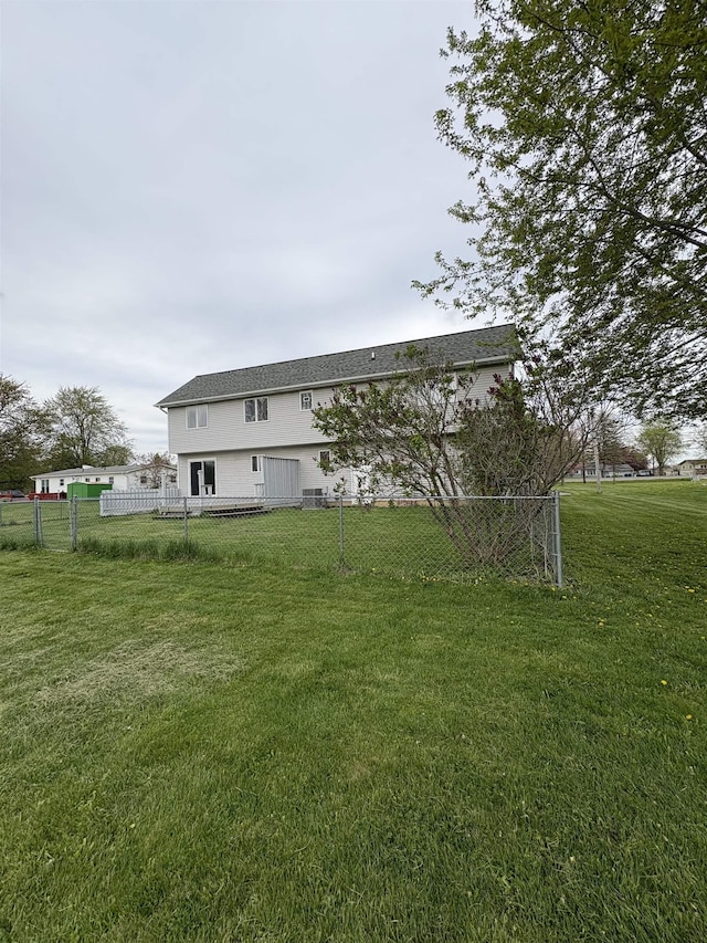 back of property with fence and a lawn