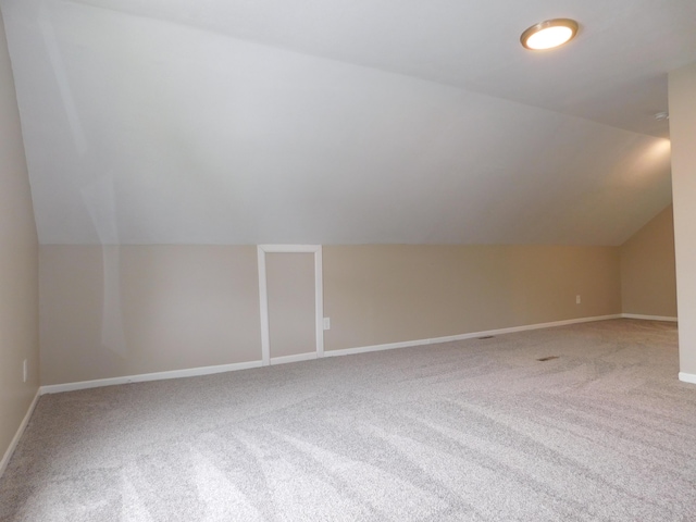 additional living space with lofted ceiling, carpet flooring, and baseboards