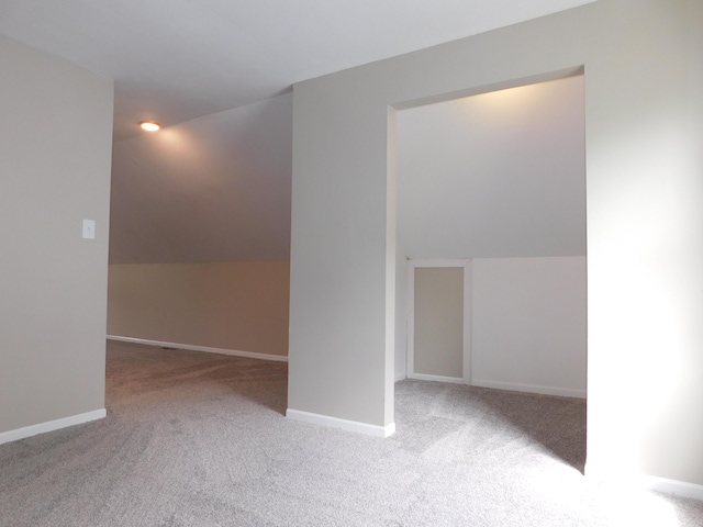 additional living space featuring vaulted ceiling, baseboards, and carpet floors