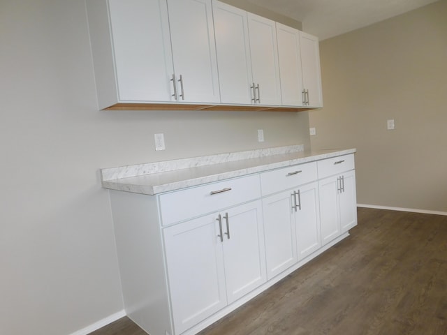 kitchen with light countertops, white cabinets, baseboards, and dark wood finished floors