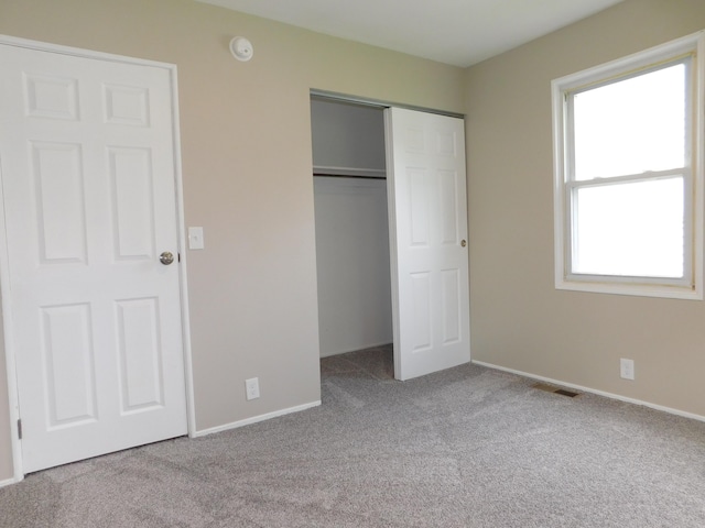 unfurnished bedroom with carpet flooring, a closet, and baseboards