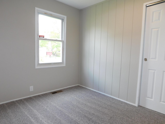 empty room with carpet flooring, baseboards, and visible vents